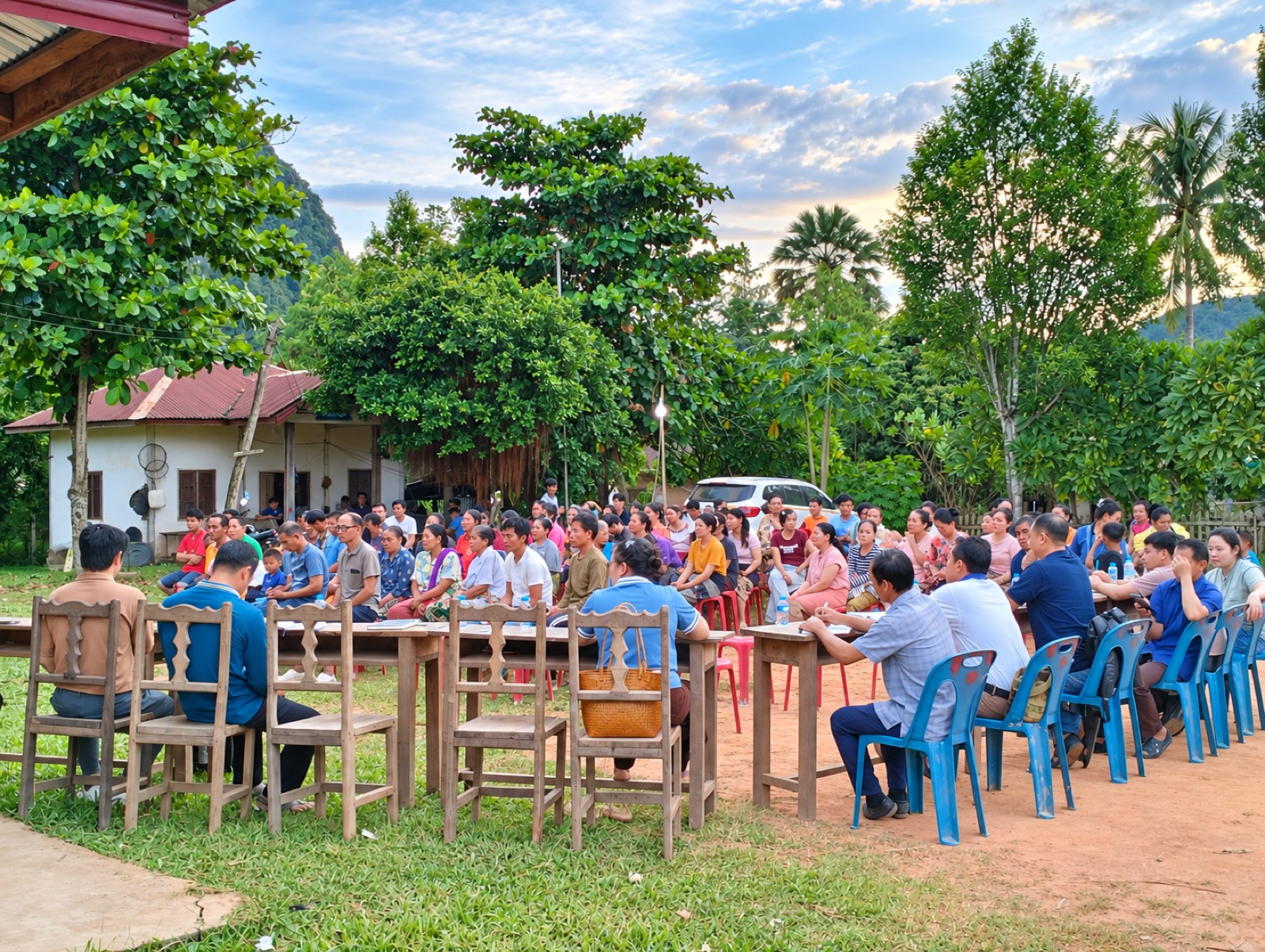 Villagers gathered outdoors for a community consultation meeting with project staff