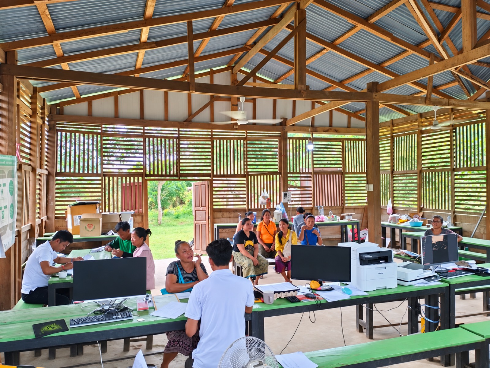 Community members meeting with project staff at a village registration office